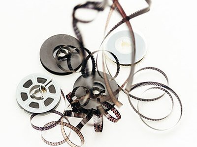 Super 8 films hanging with reels on white background
